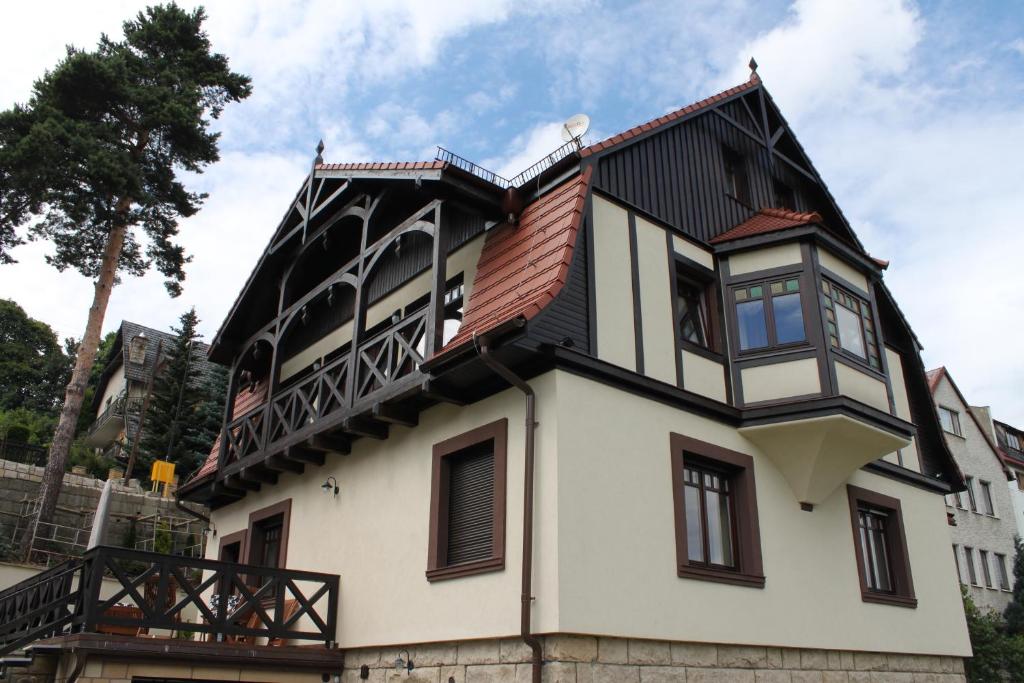 een huis met een balkon er bovenop bij Willa Lawenda in Duszniki Zdrój