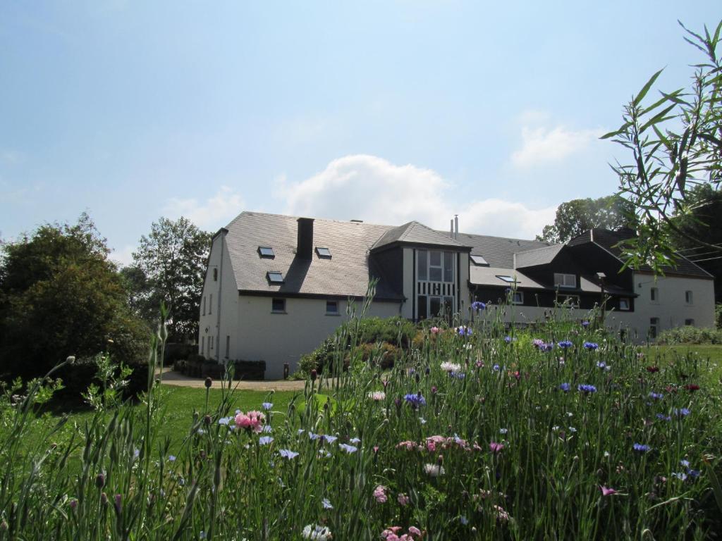 a house with a field of flowers in front of it at Energîte in Tillet