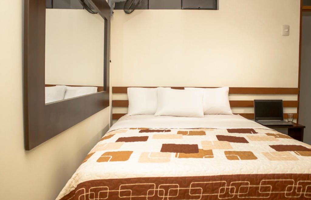 sypialnia z łóżkiem i lustrem w obiekcie Muchick w mieście Chiclayo