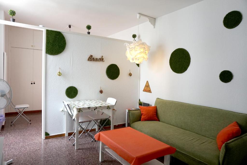 ein Wohnzimmer mit einem grünen Sofa und einem Tisch in der Unterkunft Mai City Apartment in Las Palmas de Gran Canaria