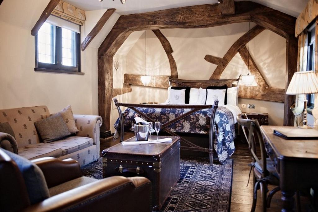 a bedroom with a bed and a couch and a table at The White Swan Hotel in Stratford-upon-Avon