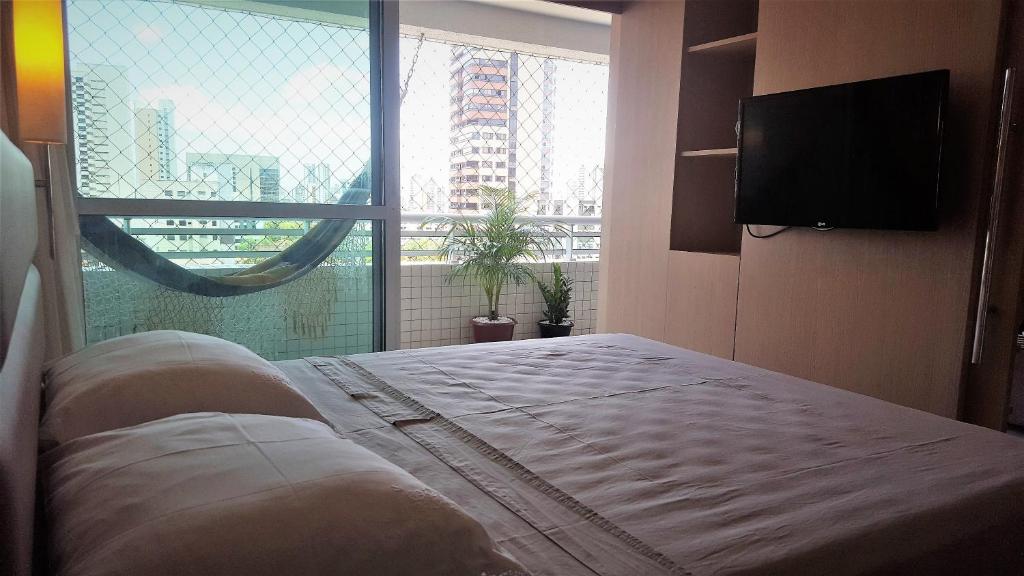 a bedroom with a bed and a large window at Beach Class Rosalux in Fortaleza