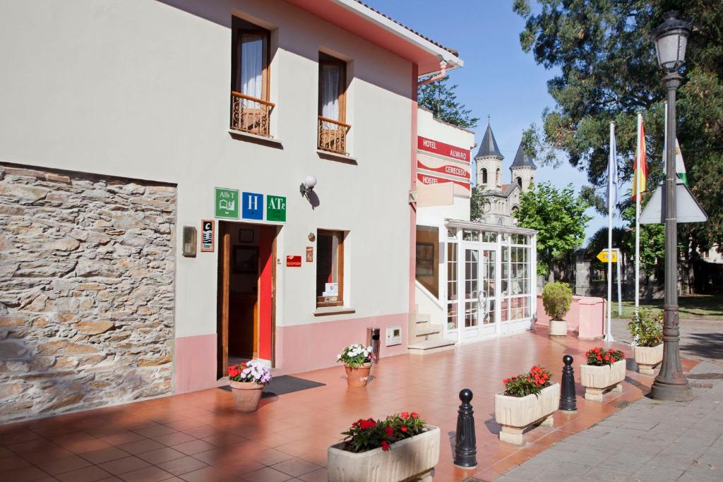 a building with flowers in pots on a sidewalk at Hotel Alvaro frente Palacio-Museo Selgas in Cudillero