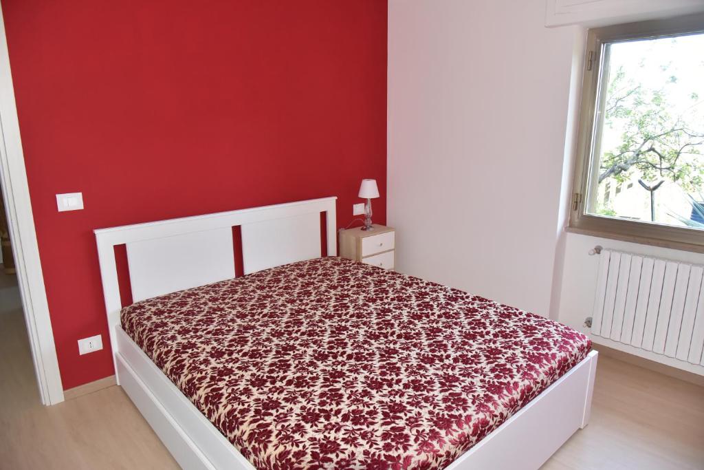 a bedroom with a bed with a red wall at Casa Annadelia in Silvi Paese