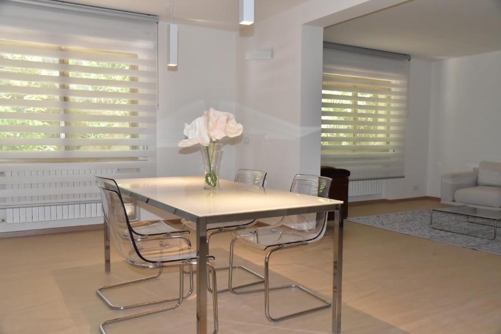 a dining room table with chairs and a vase with flowers at Casa Annadelia in Silvi Paese