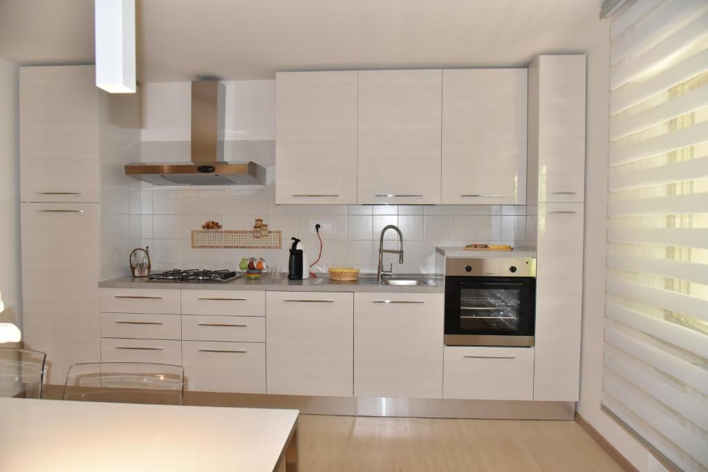 a white kitchen with white cabinets and a stove at Casa Annadelia in Silvi Paese