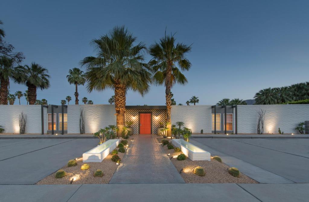 una casa con palmeras y una puerta roja en the Weekend Palm Springs en Palm Springs