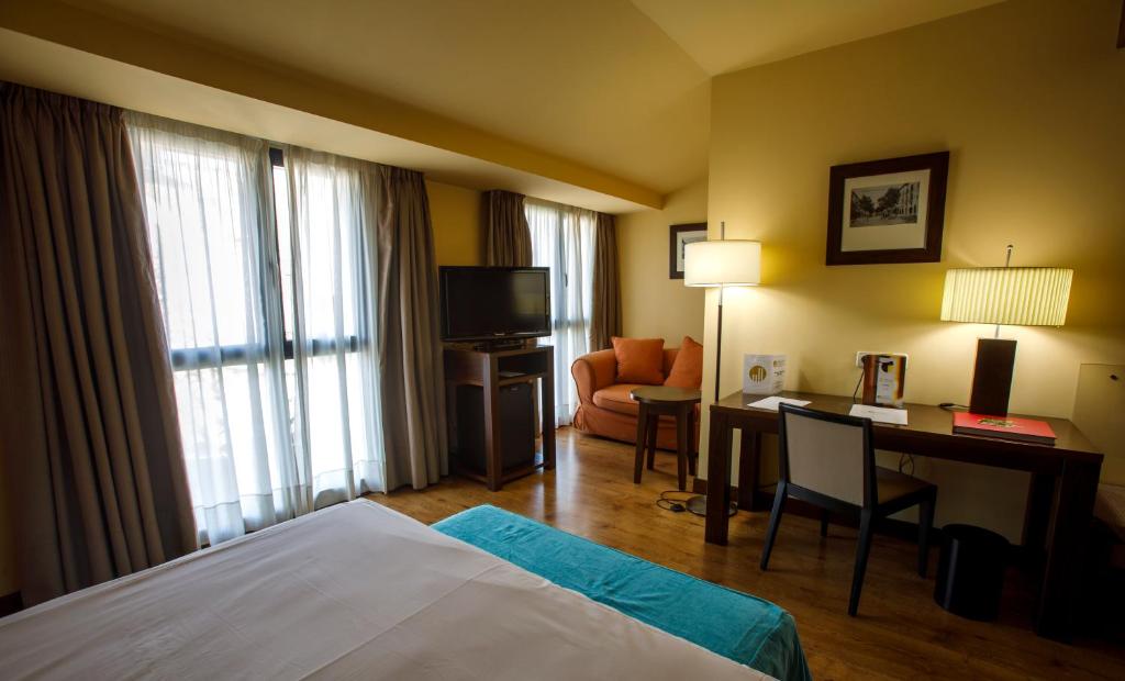 Postel nebo postele na pokoji v ubytování Gran Hotel Ciudad de Barbastro