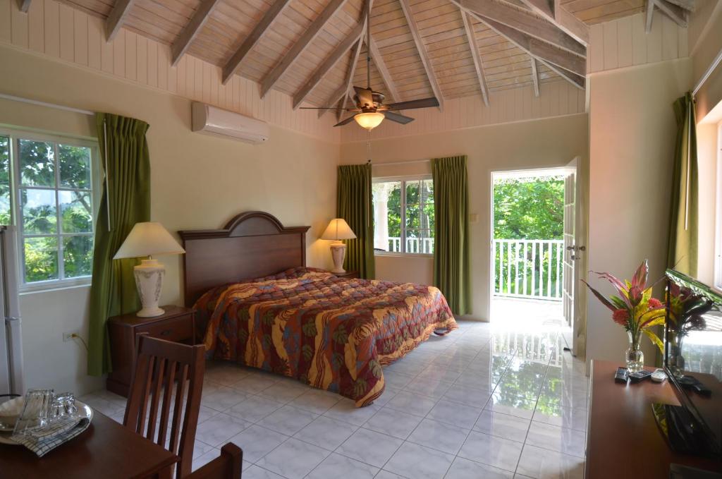 una camera da letto con un letto, un tavolo e alcune finestre di Tropical Lagoon Resort a Port Antonio