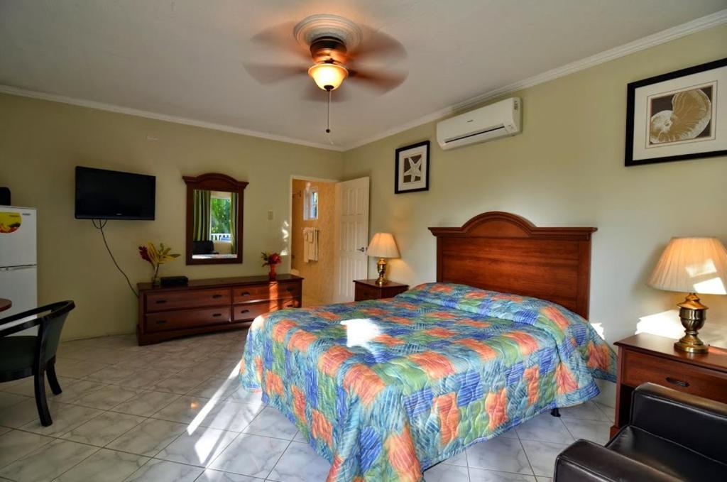 una camera con letto e ventilatore a soffitto di Tropical Lagoon Resort a Port Antonio