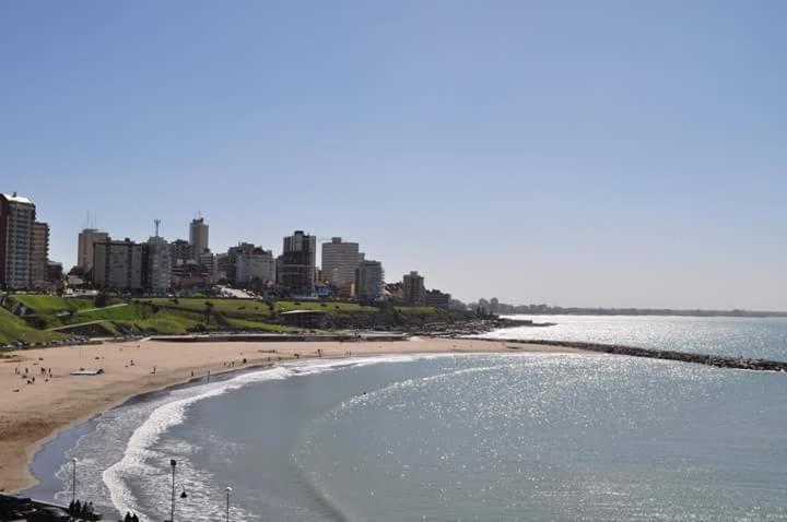 una playa con un montón de gente caminando en ella en Departamento Mar de Plata Argentina en Mar del Plata