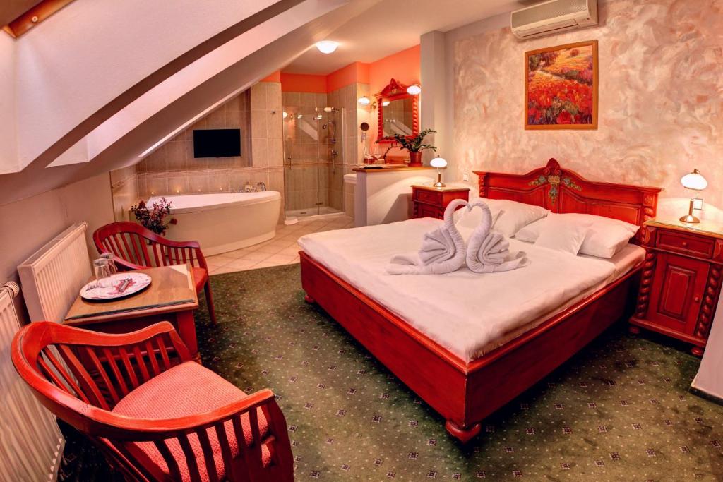 a bedroom with a bed with a bath tub and a bath tub at BIRDIE Pension & Wellness in Pardubice