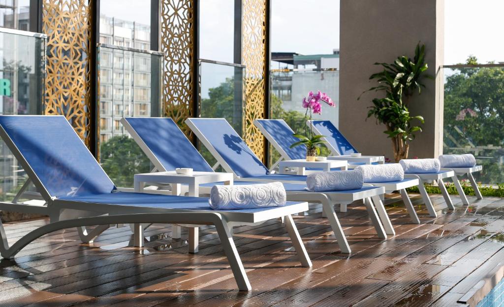 ホーチミン・シティにあるOrchids Saigon Hotelのデッキの青と白のラウンジチェア