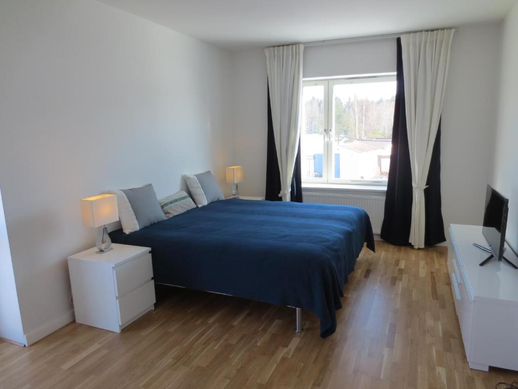 - une chambre avec un lit bleu et une fenêtre dans l'établissement Gamla Järnhandeln - Norrskedika Hotell, à Östhammar