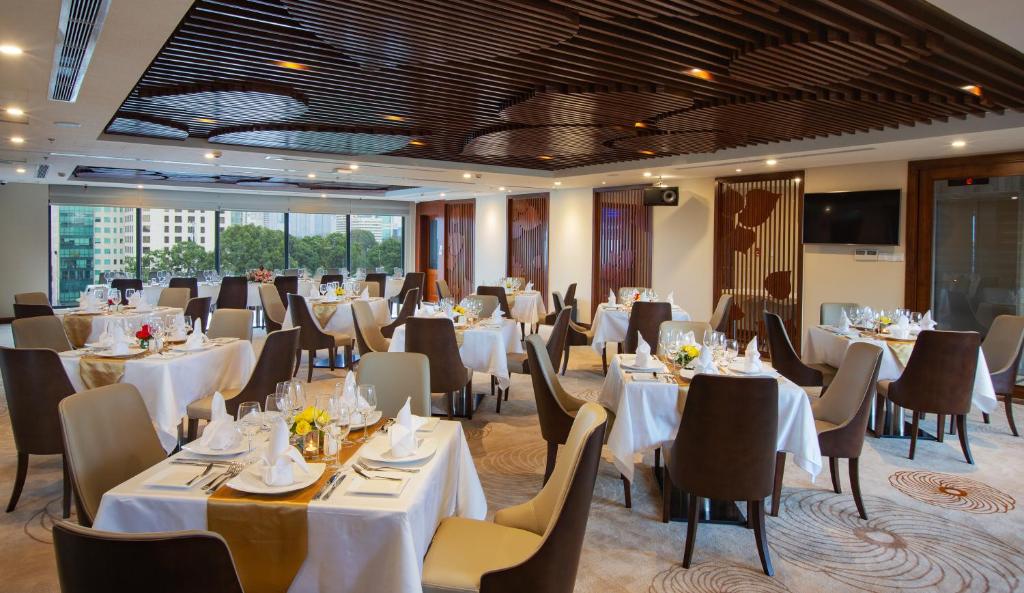 ホーチミン・シティにあるOrchids Saigon Hotelのダイニングルーム(テーブル、椅子、白いテーブルクロス付)