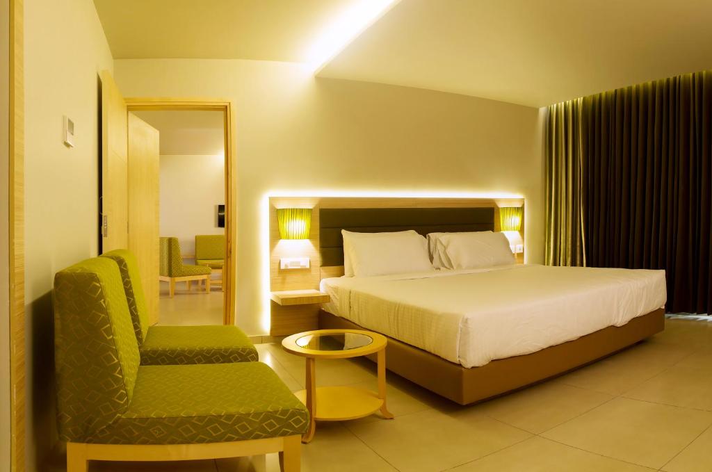 a hotel room with a bed and a chair at KVM Hotels Srirangam in Tiruchchirāppalli
