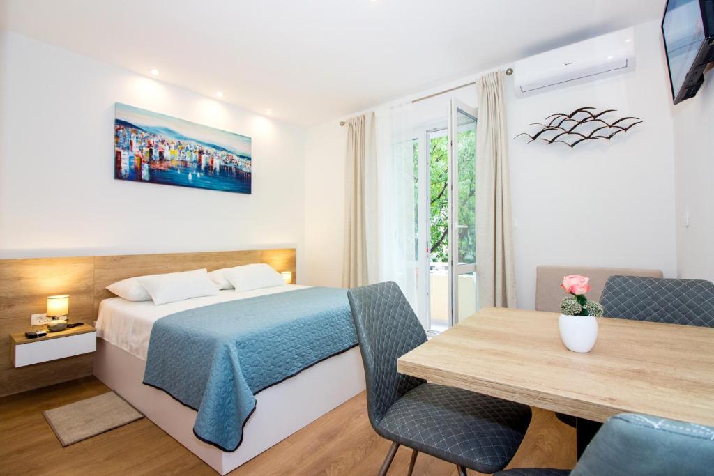 1 dormitorio con cama, escritorio y mesa en Lugo Apartments, en Split
