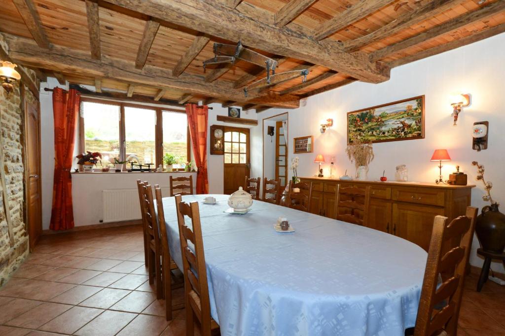 uma sala de jantar com uma mesa branca e uma cozinha em Chambres d'hôtes L'Hirondelle em Girondelle