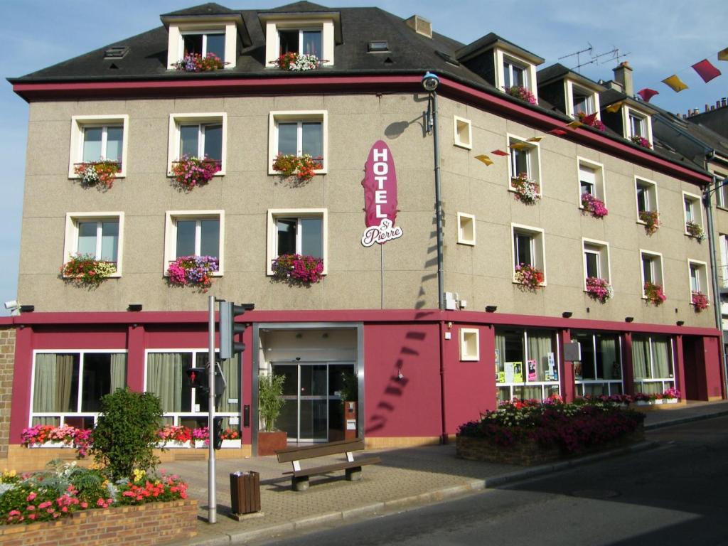 ein Gebäude mit einer Bank davor in der Unterkunft Hôtel Saint-Pierre in Vire
