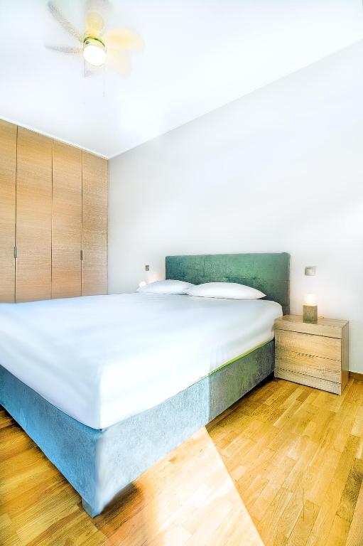 - duże białe łóżko w pokoju z drewnianą podłogą w obiekcie Luxurious 2bedroom flat near Athens center w Atenach