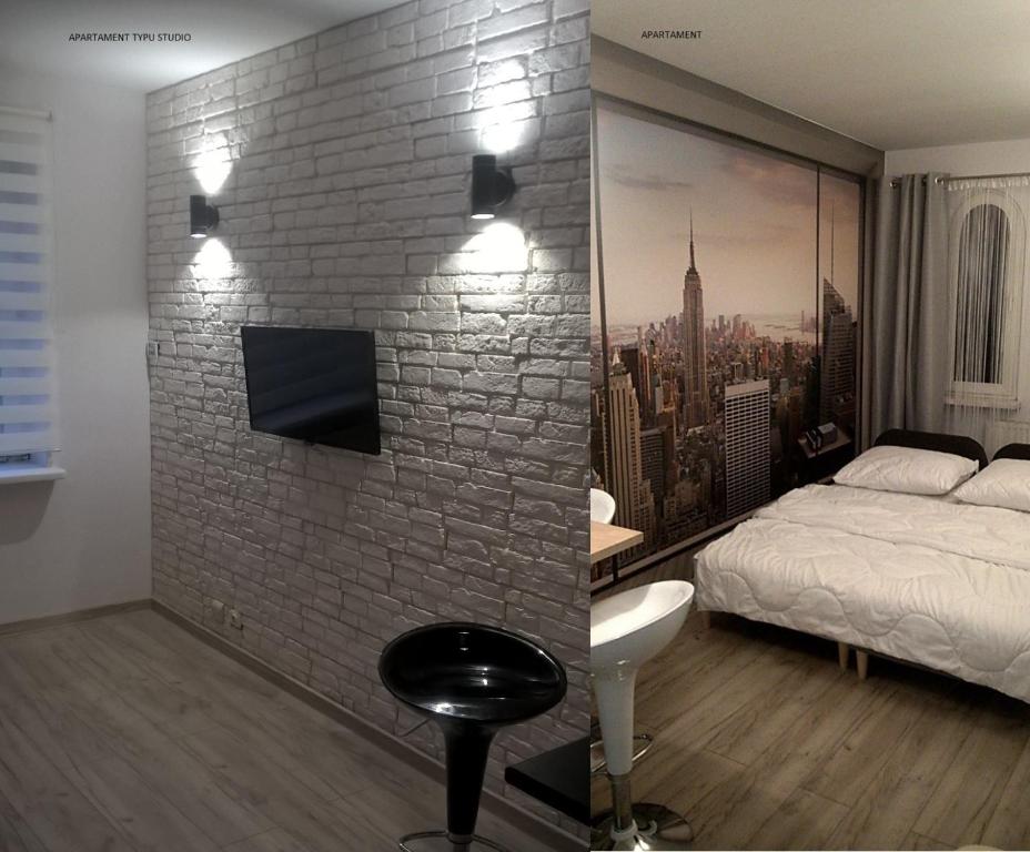 a bedroom with a brick wall with a bed and a tv at Apartamenty przy Starym Rynku in Poznań