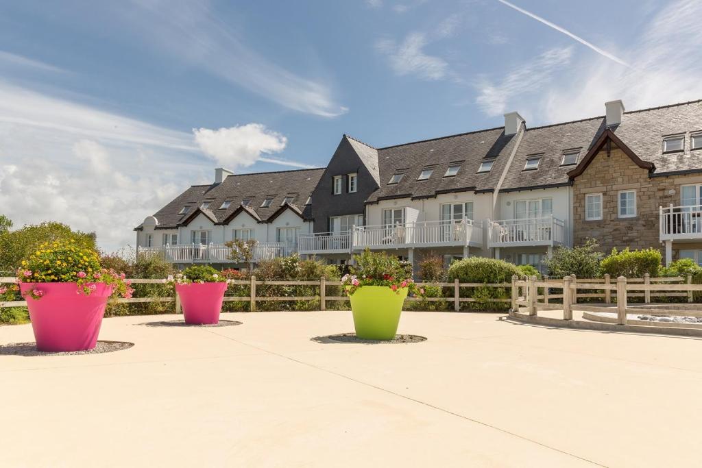 a row of potted plants in front of a building at Residence Port du Crouesty Cap Ocean - maeva Home in Arzon