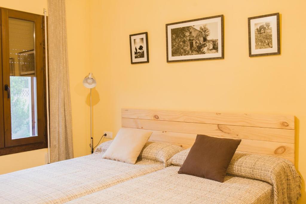 a bedroom with a bed with two pillows on it at Pou De Beca Allotjaments i agroturisme in Vall dʼAlba