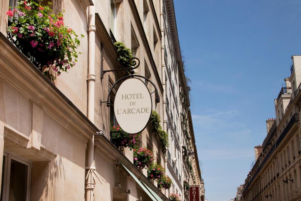 ein Schild für ein Hotel an der Seite eines Gebäudes in der Unterkunft Hôtel De l'Arcade in Paris