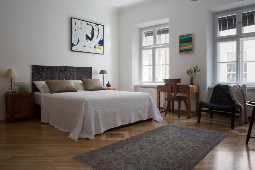 um quarto branco com uma cama, uma mesa e cadeiras em Apartment Jasmin em Zagreb