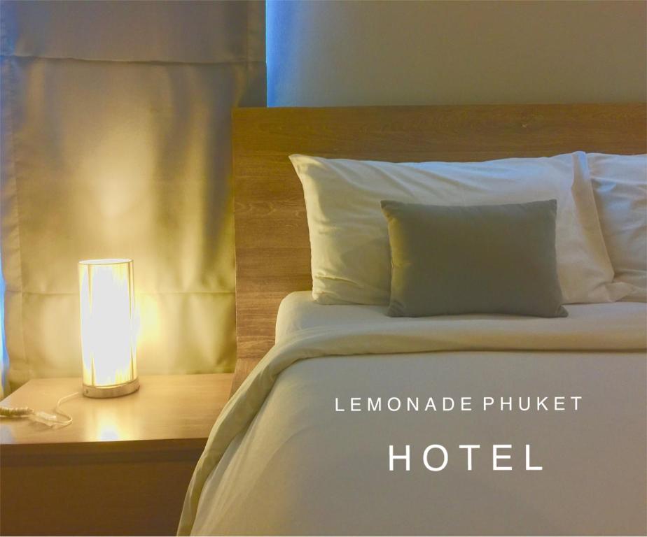 ein Schlafzimmer mit einem Bett und einer Lampe auf einem Tisch in der Unterkunft Lemonade Phuket Hotel -SHA Plus in Chalong 
