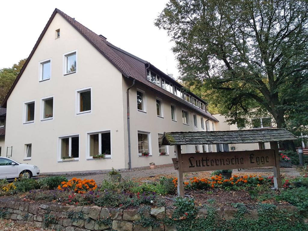 un bâtiment blanc avec un panneau devant lui dans l'établissement Berghotel, à Bad Oeynhausen