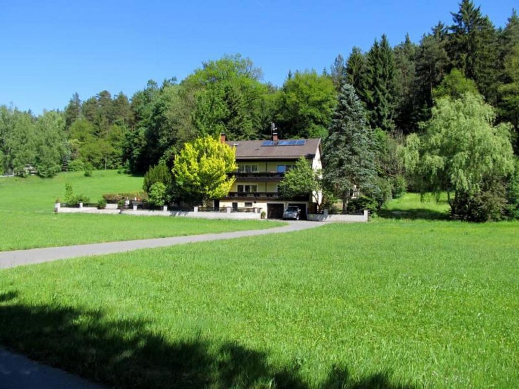 a house in the middle of a green field at Haus am Wald in Bad Koetzting