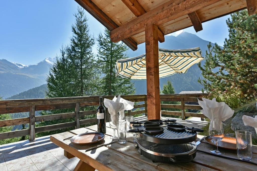 - une table en bois avec de la nourriture au-dessus d'une terrasse dans l'établissement Chalet Diana, à Grimentz