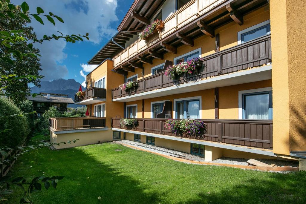 un bâtiment avec des boîtes de fleurs sur les balcons dans l'établissement Amadeus Appartement, à St. Johann in Tirol