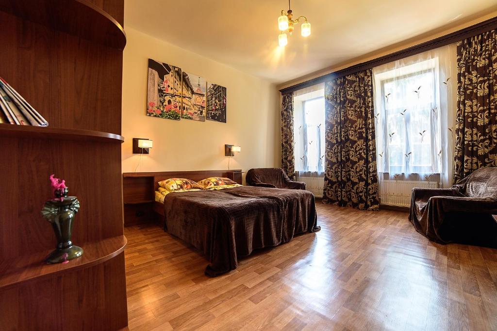 a bedroom with a bed and a couch and a window at Apartments Nekrasova-Rufa 23 in Lviv