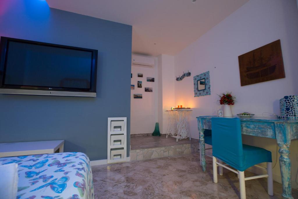 a blue room with a table and a tv on a wall at Versomare in Polignano a Mare