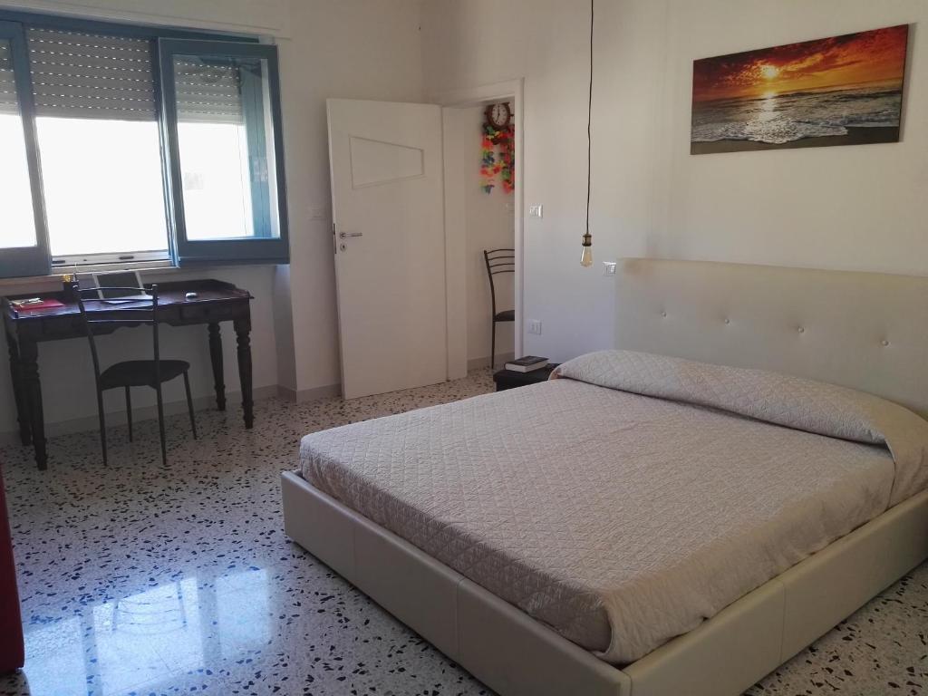 1 dormitorio con cama, escritorio y mesa en Casa Lulù, en Presicce