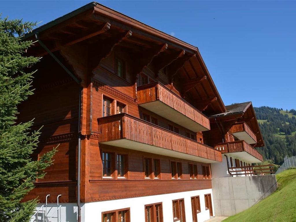 a large building with balconies on the side of it at Apartment Henry - Tiefparterre by Interhome in Gstaad