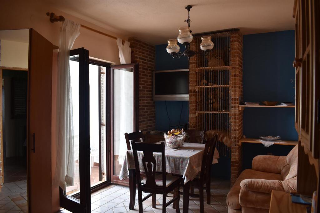 comedor con mesa, sillas y paredes azules en Apartments Radnić, en Pag