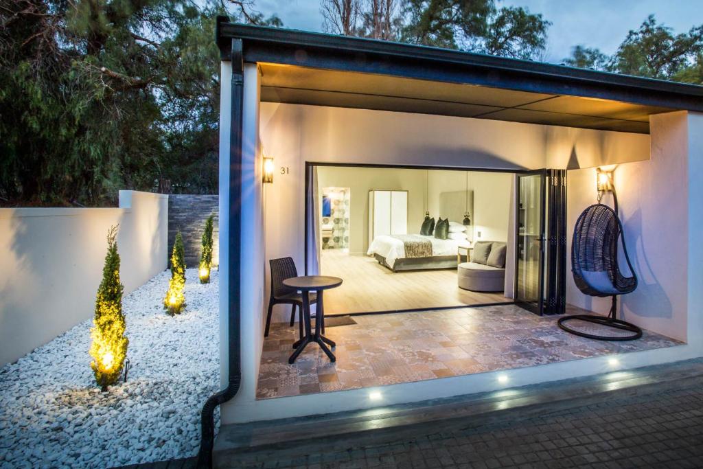 a room with a view of a bedroom at Hlangana Lodge in Oudtshoorn