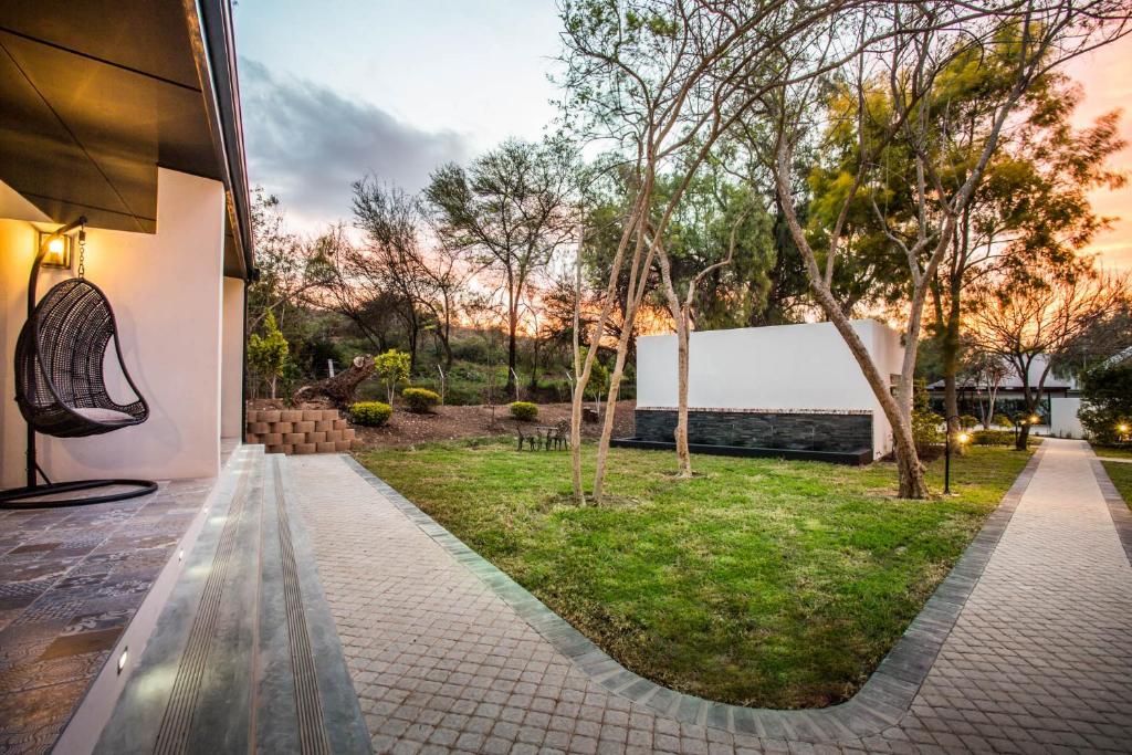 a view of a garden from a house at Hlangana Lodge in Oudtshoorn