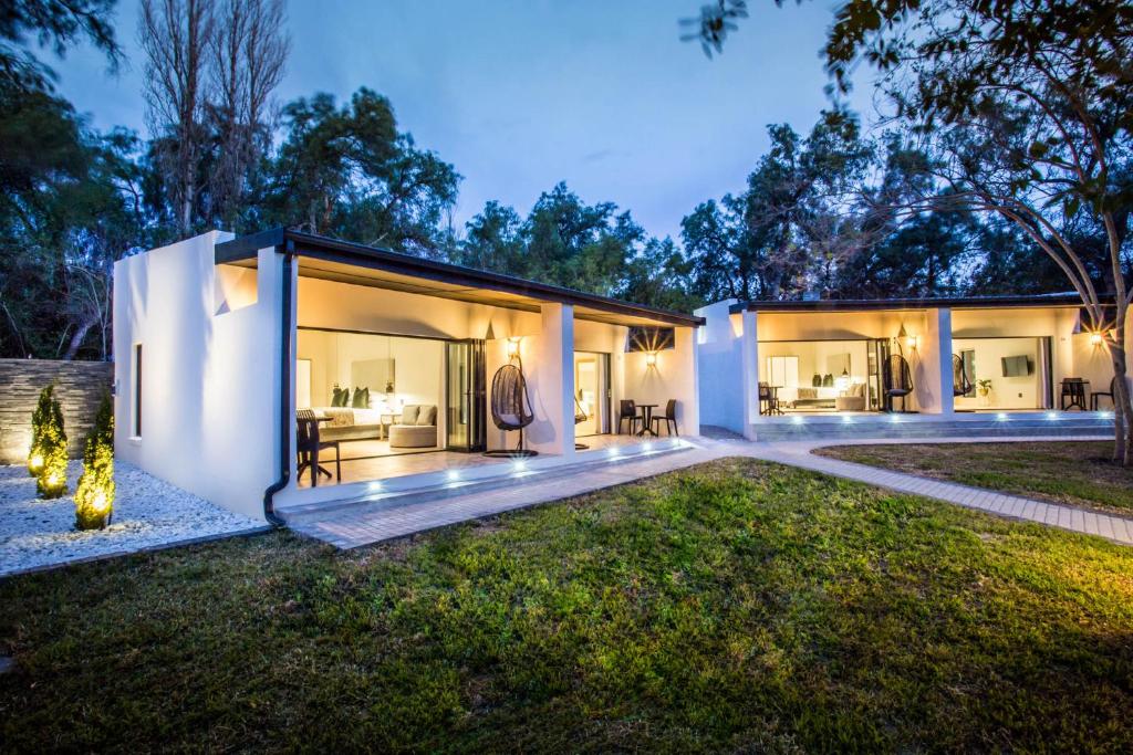 an exterior view of a house with a yard at Hlangana Lodge in Oudtshoorn