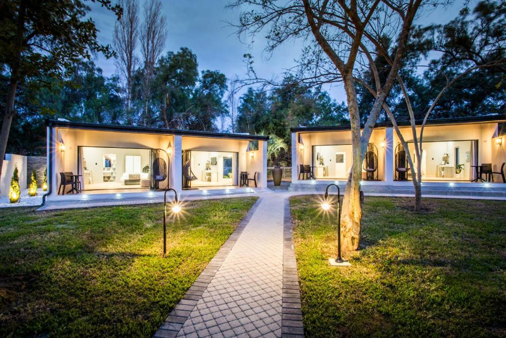 a house with lights in the yard at night at Hlangana Lodge in Oudtshoorn