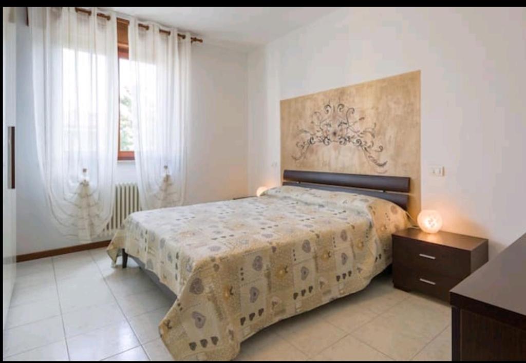 Schlafzimmer mit einem Bett, einer Kommode und Fenstern in der Unterkunft Yellow house in Vicenza