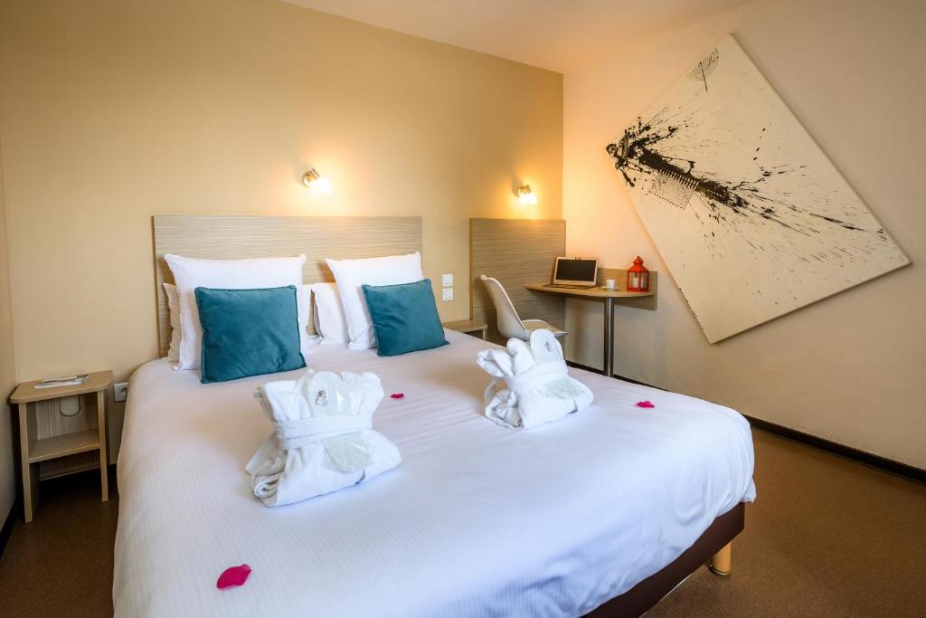 Postel nebo postele na pokoji v ubytování LOGIS Hôtel Restaurant Le Clos Fleuri