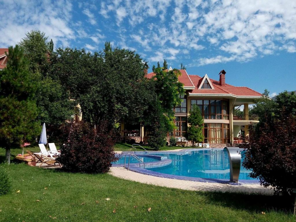 a large house with a swimming pool in front of it at Green Canyon Uzbekistan in Yusufkhona