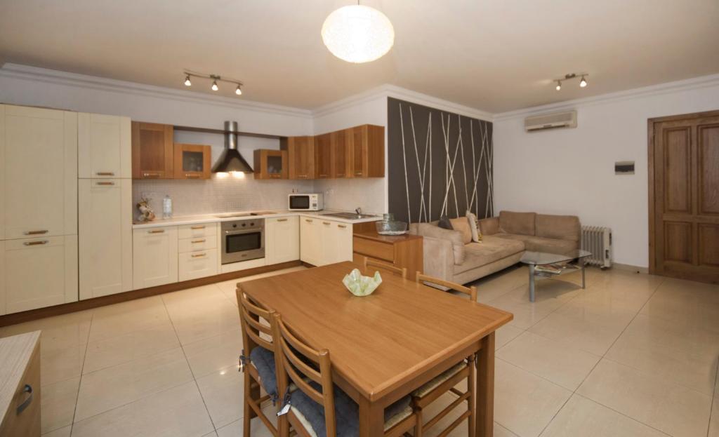 eine Küche und ein Wohnzimmer mit einem Tisch und einem Sofa in der Unterkunft BV7 - Bridge View Apartment in St Julian's