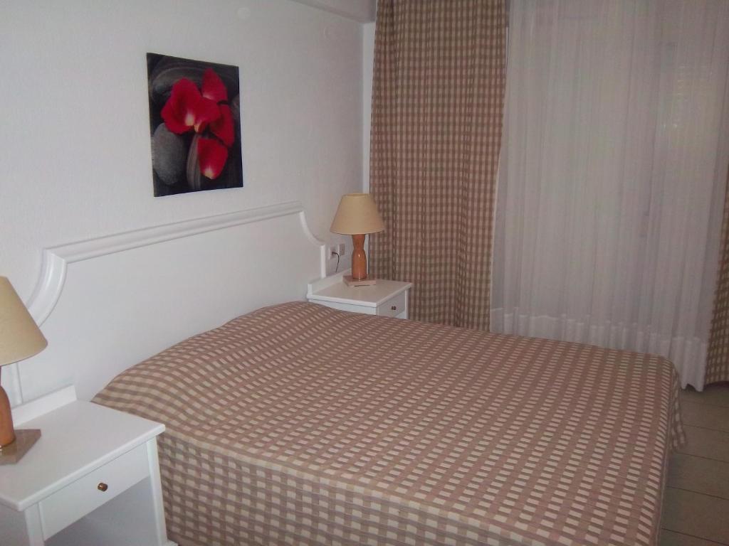 a bedroom with a bed and a red flower on the wall at Milos Apartments in Afitos