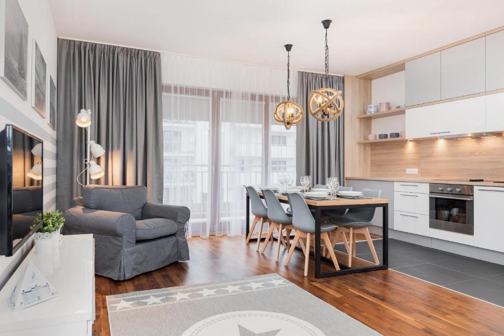 a kitchen and living room with a table and chairs at Platan Apartments Świnoujście Center IV by Renters in Świnoujście