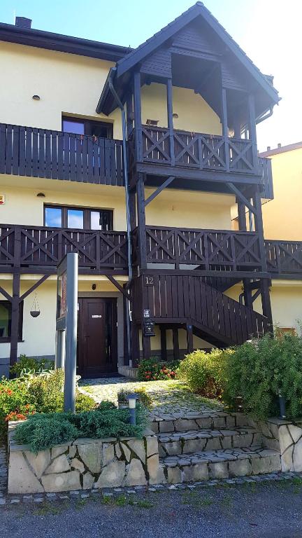 a large house with a large deck on it at Dom Gościnny Trojak in Lądek-Zdrój